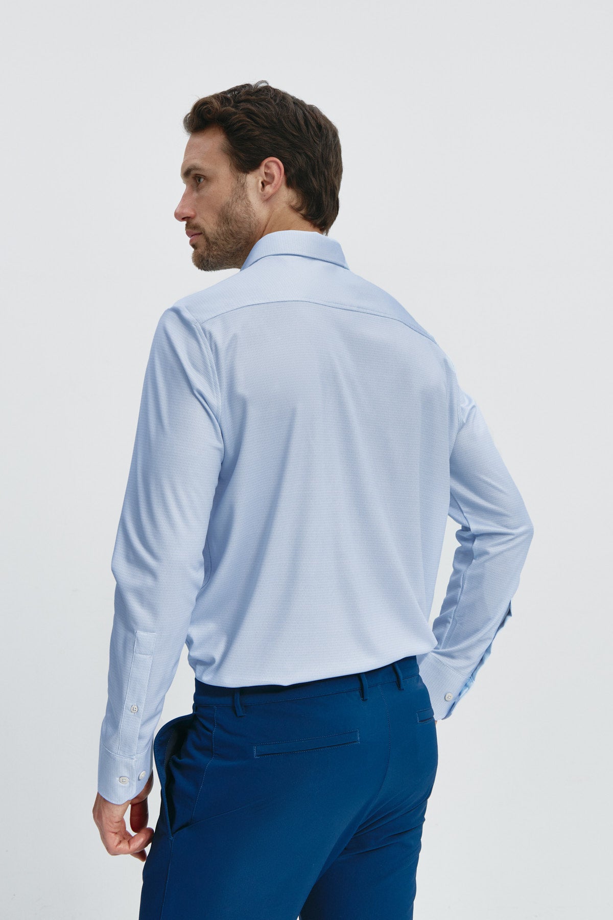 Camisa de vestir regular fit para hombre azul: Camisa de vestir regular fit para hombre en color azul, sin arrugas, antimanchas, elegante y cómoda. Foto de espalda.