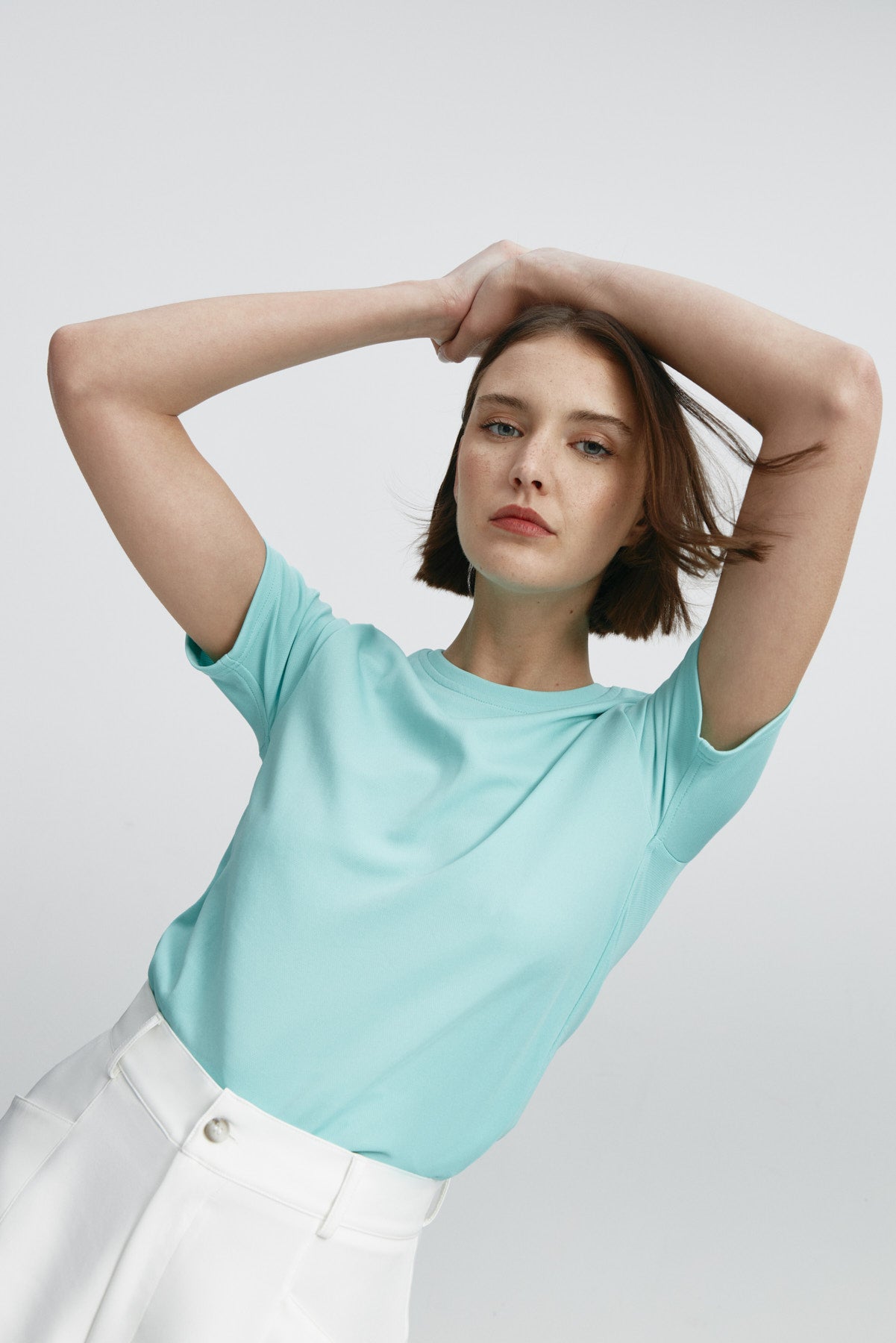 Camiseta ICE de mujer azual aqua de manga corta, antiarrugas y antimanchas. Foto flexibilidad
