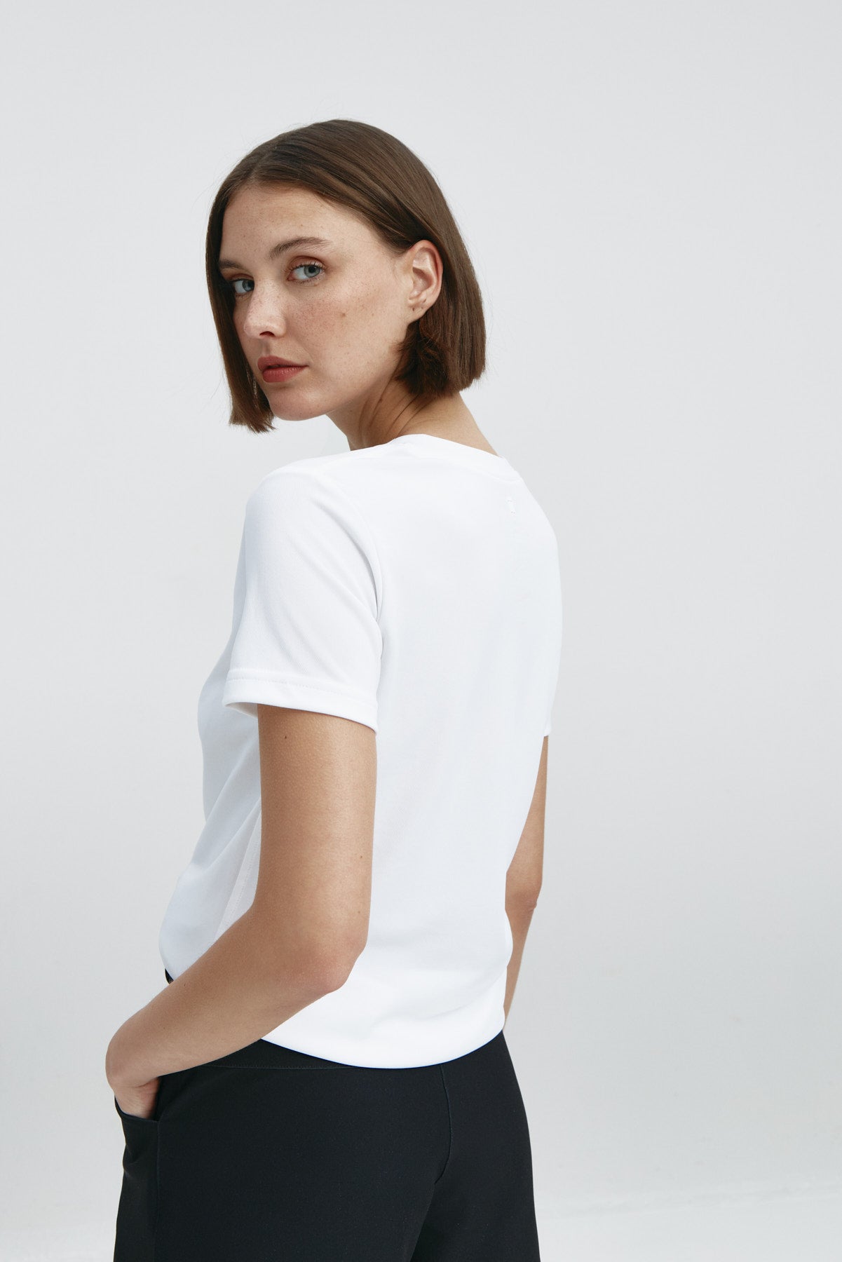 Camiseta básica de mujer blanca de manga corta, antiarrugas y antimanchas. Foto espalda