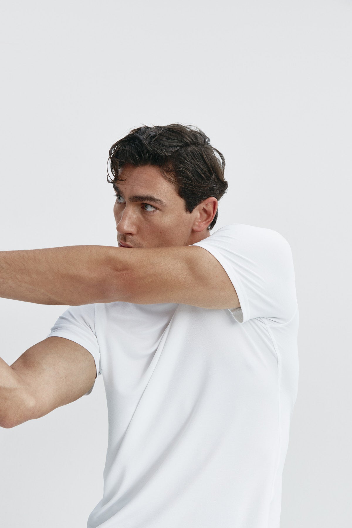 Camiseta de hombre blanca de manga corta, antiarrugas y antimanchas. Foto flexibilidad.