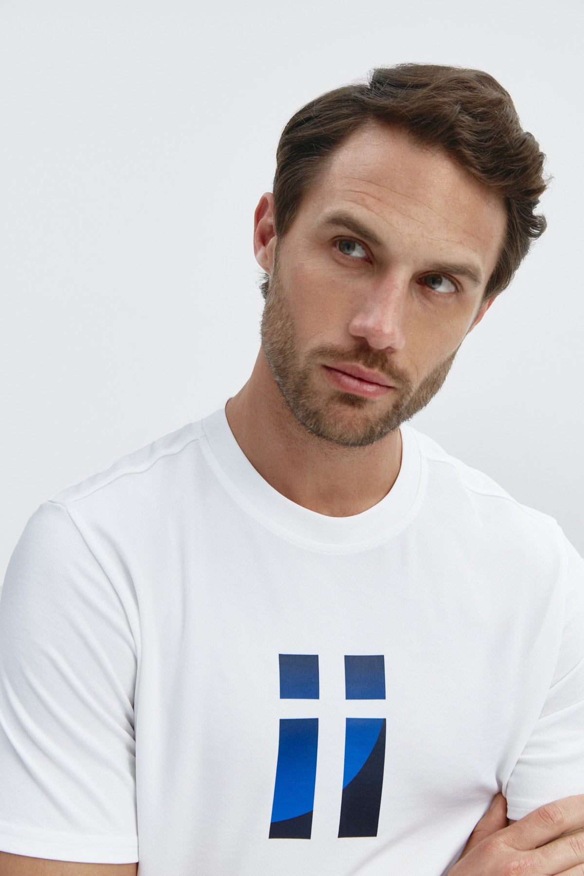 Camiseta básica de hombre blanca con logo estampado de aleta de manga corta, antiarrugas y antimanchas. Foto retrato