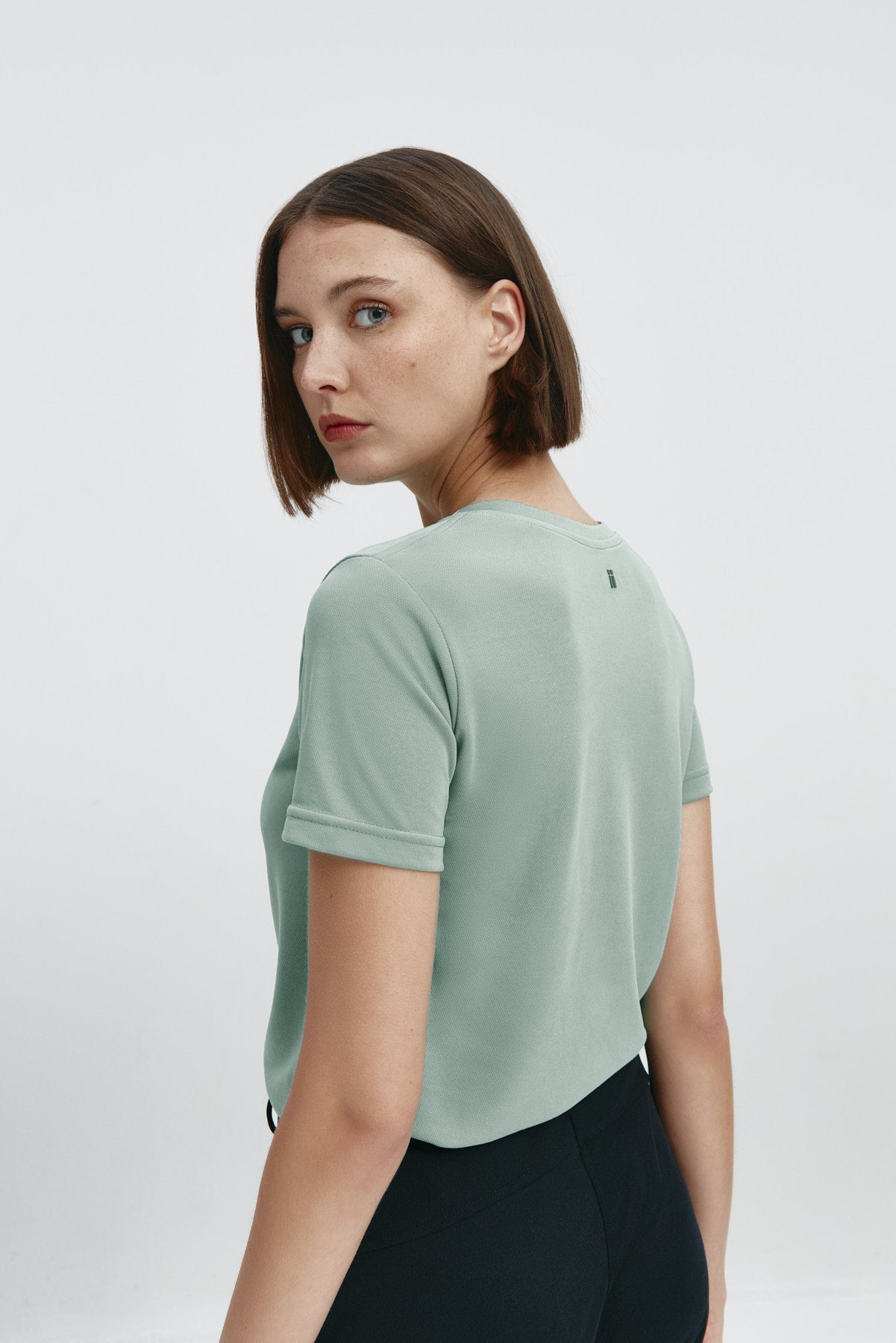 Camiseta básica de mujer verde cuarzo de manga corta y cuello redondo, perfecta para cualquier look. Foto espalda
