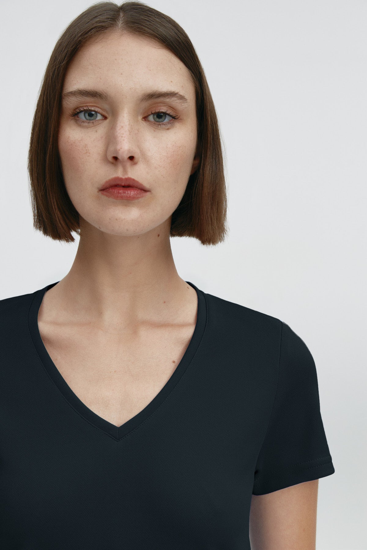 Camiseta para mujer de manga corta con escote pico color negro, básico. Foto retrato