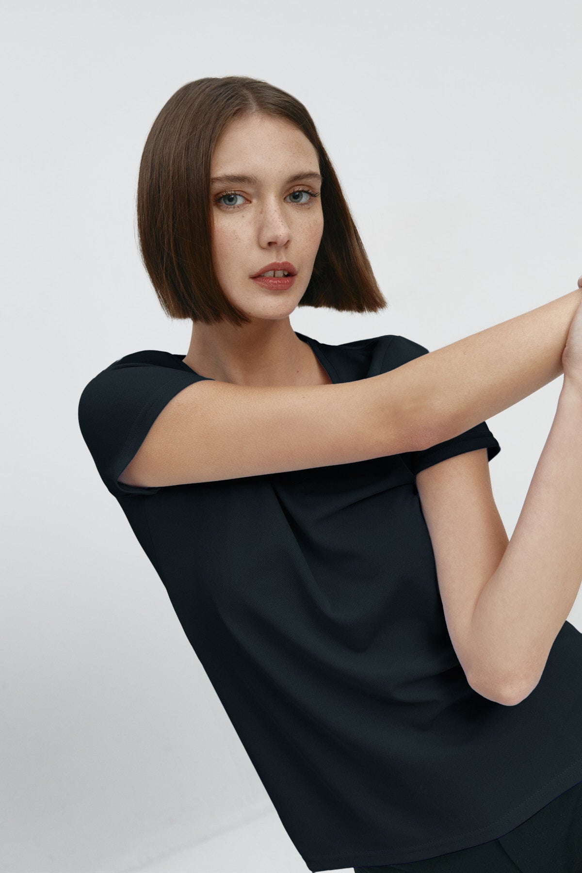 Camiseta para mujer de manga corta con escote pico color negro, básico. Foto flexibilidad