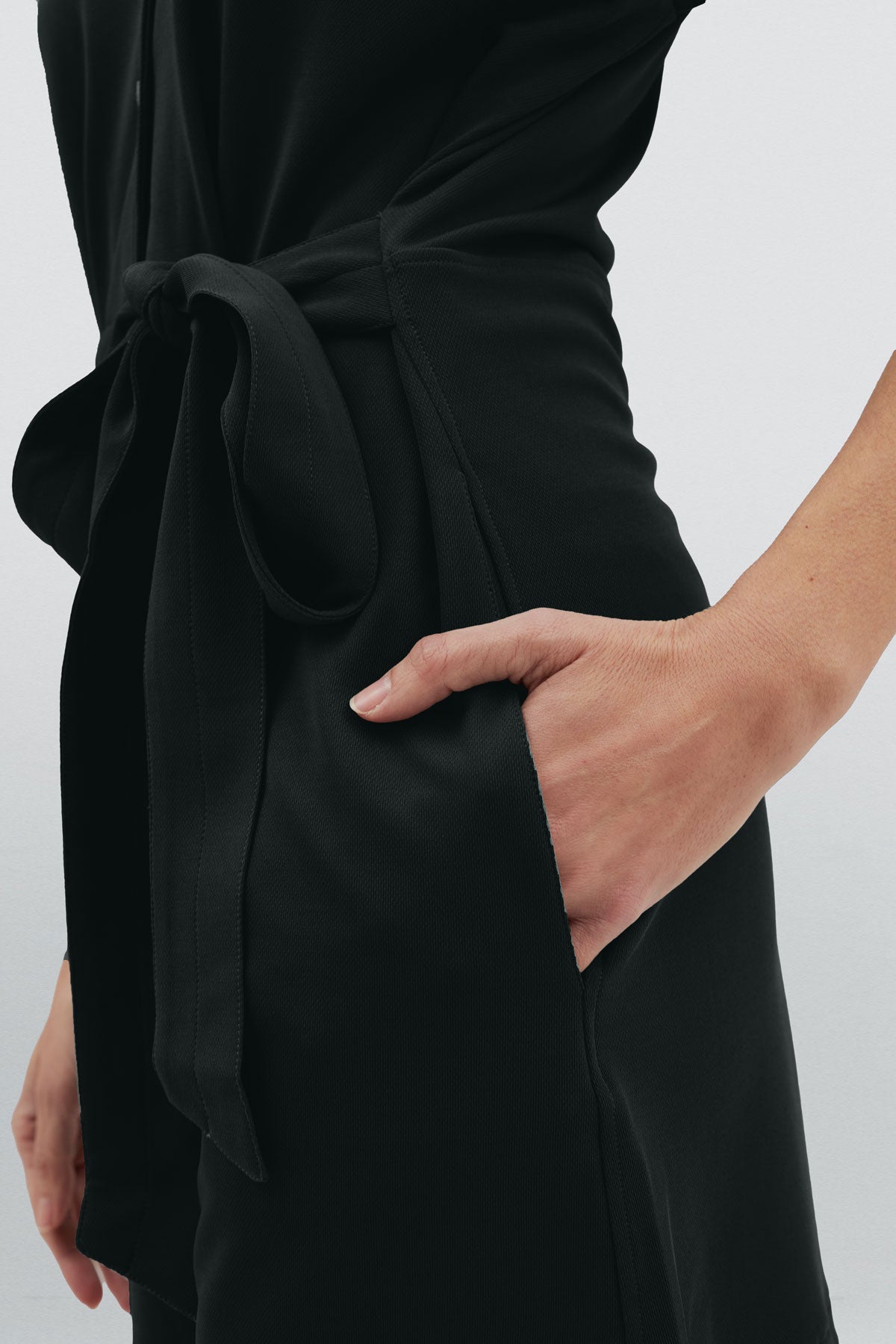 Mono corto de mujer color negro con detalle de cinturón y bolsillos laterales para mayor comodidad. Foto detalle